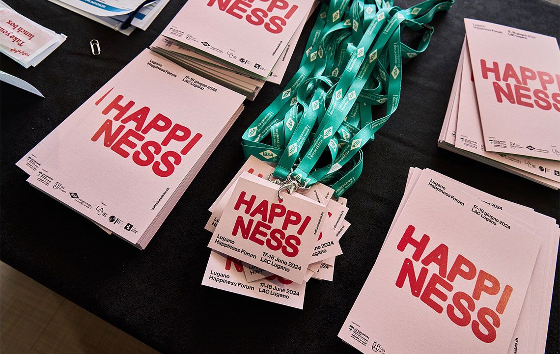 Programmi di sala e badge del Lugano Happiness Forum